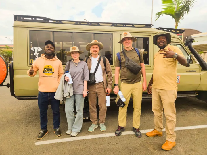 PMK safari guests with the team beside a safari Land Cruiser