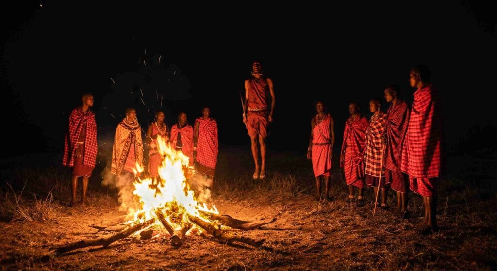 masai dancing on a camp fire in masai mara