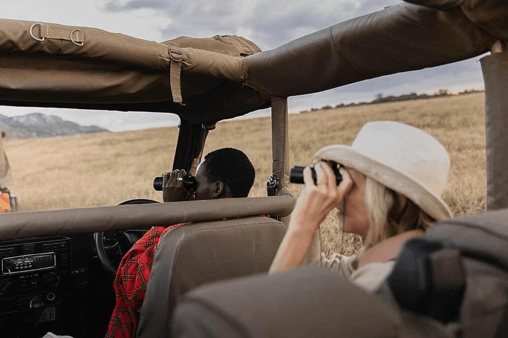 Expert Kenya safari guide helping guests spot wildlife during a game drive